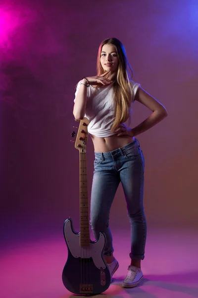 Hermosa chica en el estudio, rubia brillante, tocando la guitarra — Foto de Stock