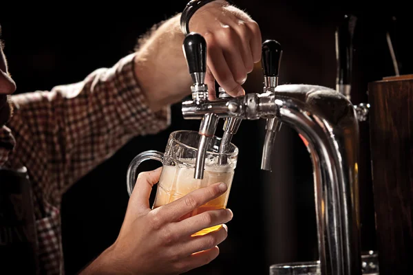 Cantinero tirando una pinta de cerveza detrás de la barra — Foto de Stock