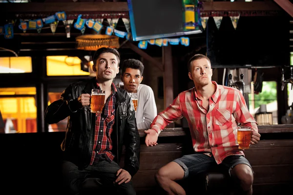 Je regarde la télé au bar. hommes boire de la bière assis bar — Photo