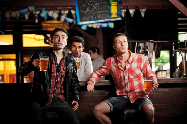 Ver televisión en el bar. hombres bebiendo cerveza bar sentado — Foto de Stock