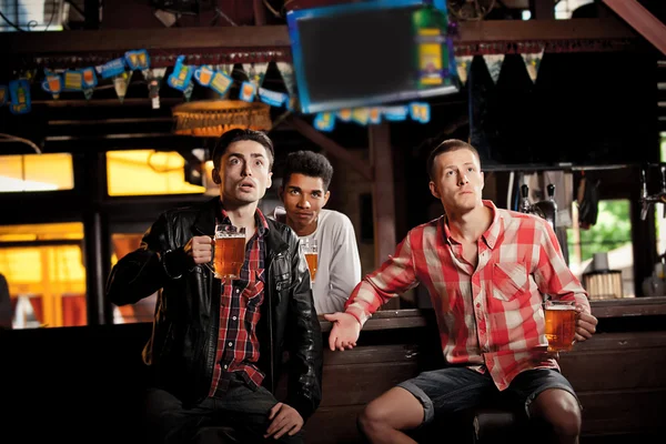 Ver televisión en el bar. hombres bebiendo cerveza bar sentado — Foto de Stock