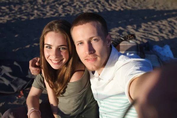 Любящая пара фотографирует себя на пляже — стоковое фото