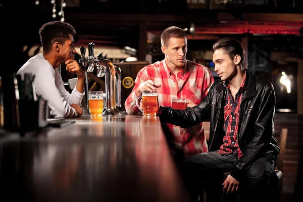 Amigos bebem cerveja e passam tempo juntos em um bar . — Fotografia de Stock