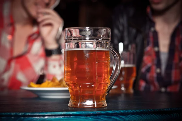 Ett glas lättöl på en mörk pub. — Stockfoto