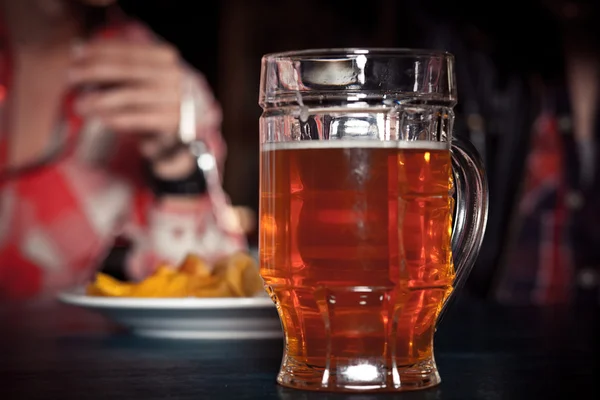 Ett glas lättöl på en mörk pub. — Stockfoto