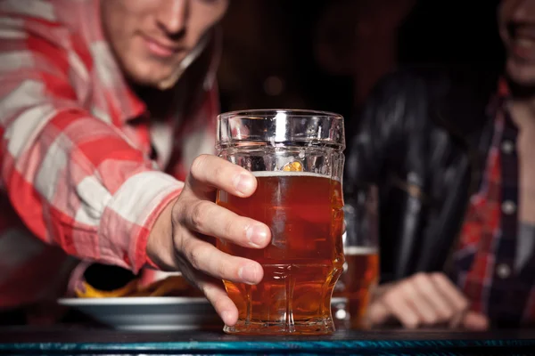 Glass of light beer on a dark pub. — Stock Photo, Image