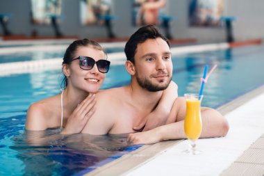 İki yüzme havuzu tarafından bir kokteyl içme ve rahatlatıcı