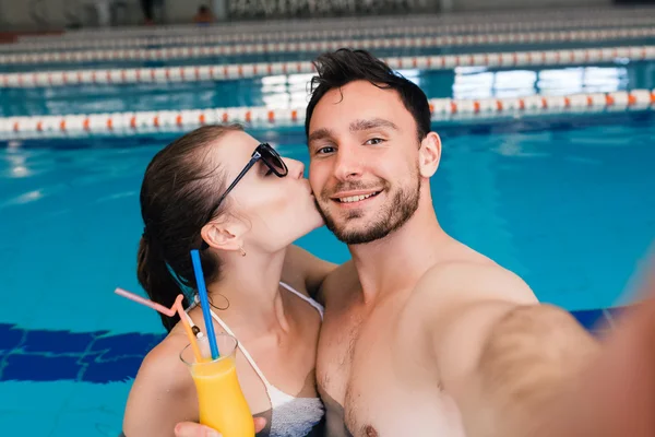 Pareja bebiendo un cóctel en la piscina y relajándose — Foto de Stock