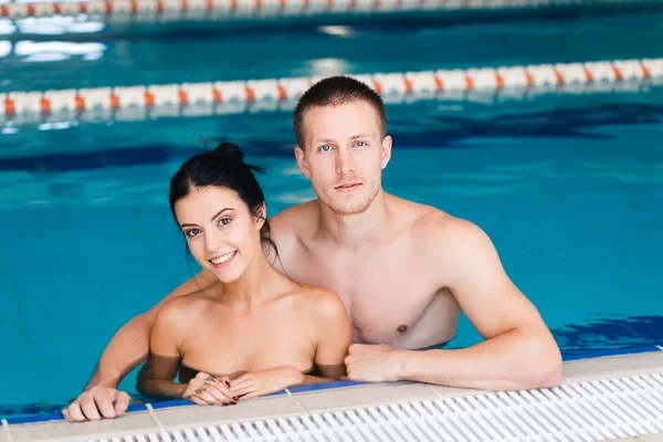 Pareja joven en la piscina — Foto de Stock