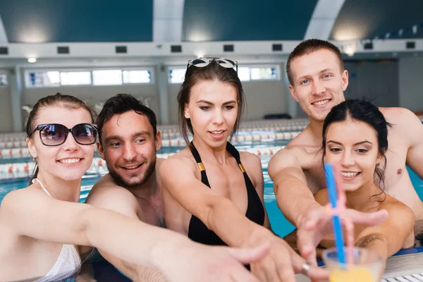 Amigos teniendo fiesta y bebiendo cubos en una piscina — Foto de Stock