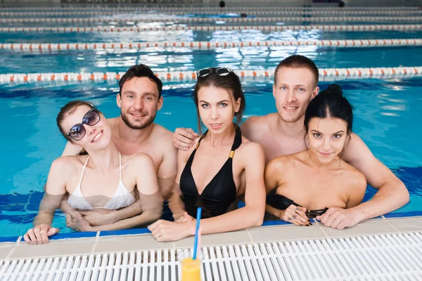 Amigos fazendo festa e bebendo baldes em uma piscina — Fotografia de Stock