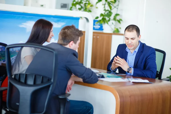 Car salesman giving key of  new car to  young  owners — Stock Photo, Image