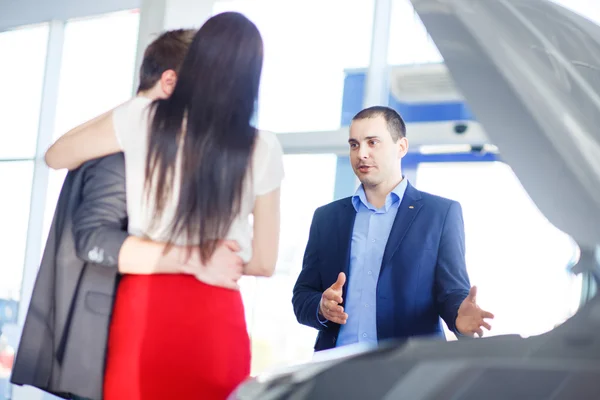 Car salesman giving key of  new car to  young  owners — Stock Photo, Image