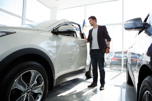 Man op zoek naar nieuwe auto in showroom — Stockfoto