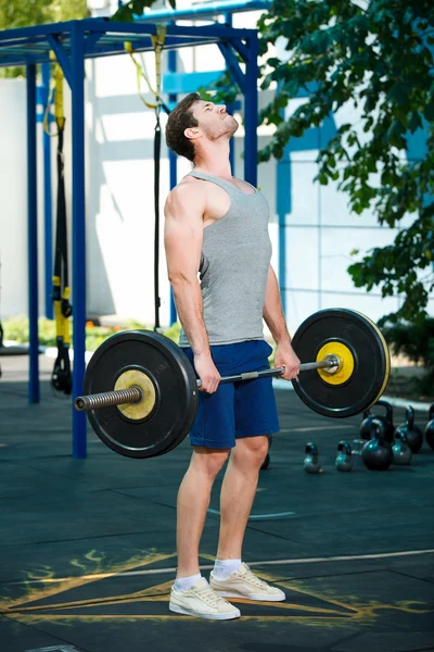 sports model exercising outside as part of healthy dumbbells