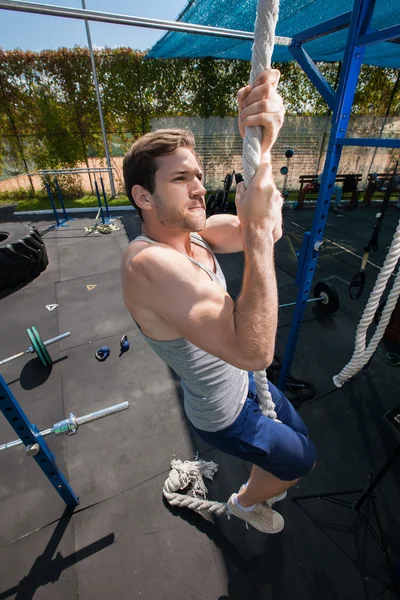 Ejercicio de escalada de cuerda de fitness en entrenamiento de gimnasio — Foto de Stock