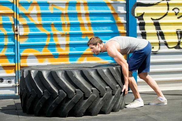 Fit girl with giant truck  workout turning tire over. — Stock Photo, Image