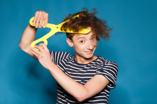 Ragazzo divertente si taglia i capelli con le forbici — Foto Stock