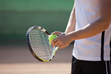 Oyuncular el ile tenis topu hizmet vermeye hazırlanıyor