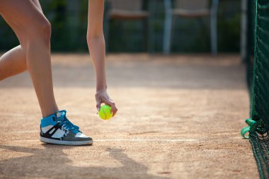 Oyuncular el ile tenis topu hizmet vermeye hazırlanıyor
