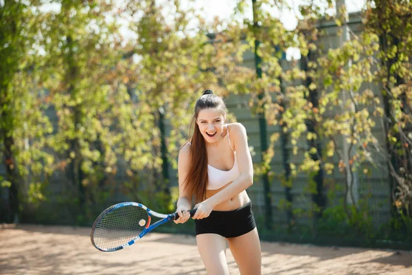 Nuori urheilullinen tyttö pelaa tennistä — kuvapankkivalokuva