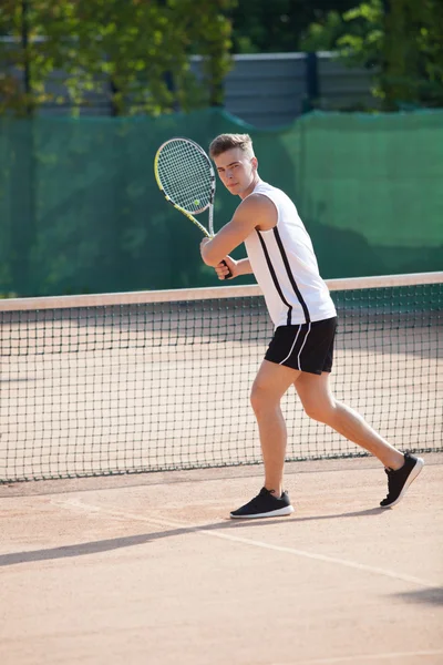 Young man play tennis outdoor on orange  court — Stock Photo, Image