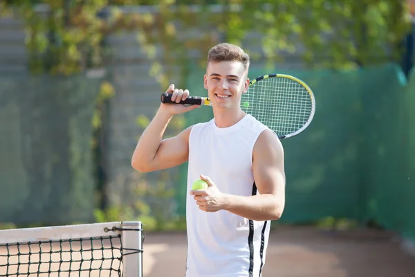 Young man play tennis outdoor on orange  court — Stock Photo, Image