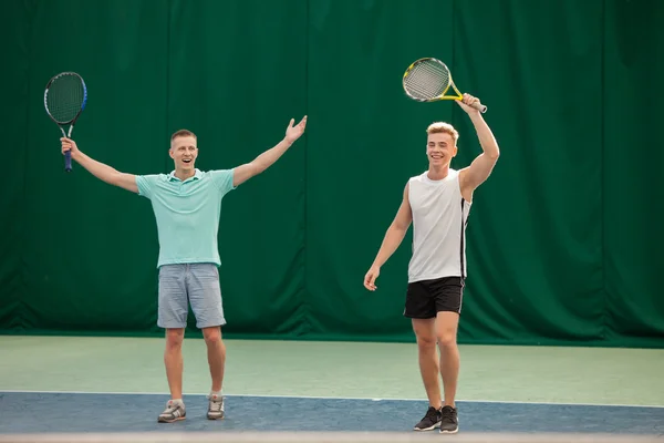 Gemengddubbel speler tennisbal raken met partner — Stockfoto