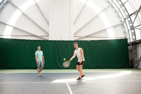 Mixed doubles player hitting tennis ball with partner — Stock Photo, Image