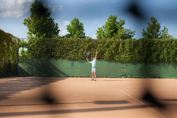 Young man play tennis outdoor on orange  court — Stock Photo, Image