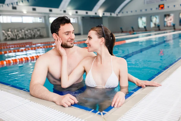 Pareja joven en la piscina — Foto de Stock