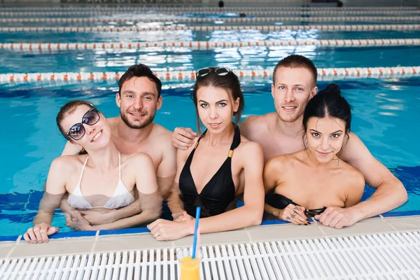 Amigos teniendo fiesta y bebiendo cubos en una piscina — Foto de Stock