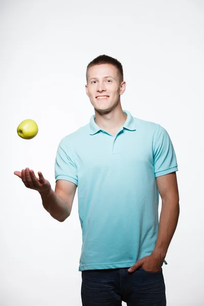 Joven guapo posando con manzana en la mano — Foto de Stock