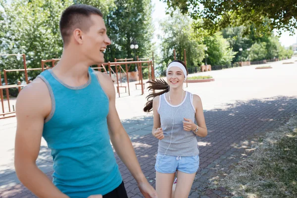 Pareja joven corriendo en el parque por la mañana. Salud y estado físico . — Foto de Stock