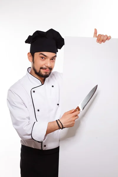 Schöner Koch in Uniform und Hut gestikulierend mit großem Messer — Stockfoto