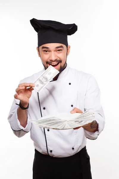 Šťastný muž v uniformě cook drží peníze na bílém pozadí — Stock fotografie