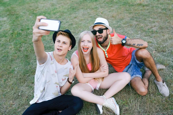 Technology and people concept - group  friends with tablet pc computers , smartphone sitting  in park — Stock Photo, Image