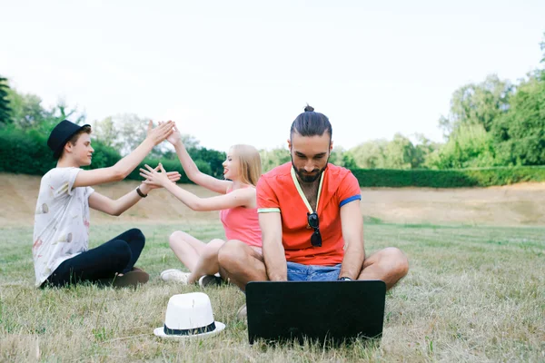 Technology and people concept - group  friends with tablet pc computers , smartphone sitting  in park — Stock Photo, Image