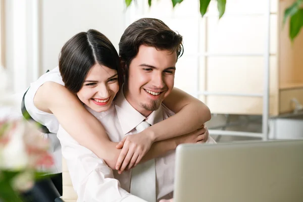 Gelukkige jonge ontspannen paar werken op laptopcomputer — Stockfoto