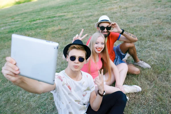 La tecnología y el concepto de personas - grupo de amigos con tabletas PC, teléfono inteligente sentado en el parque — Foto de Stock