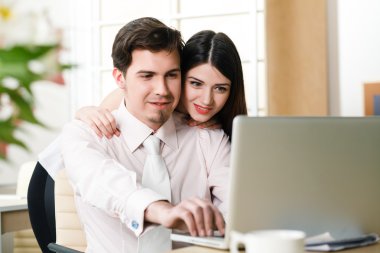 mutlu genç rahat çift dizüstü bilgisayar üzerinde çalışan