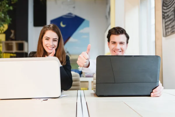 Feliz jovem casal relaxado trabalhando no computador portátil — Fotografia de Stock