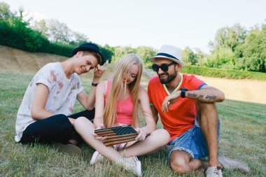 teknoloji ve insan kavramı - grup arkadaşları ile tablet pc bilgisayar, parkta oturan smartphone