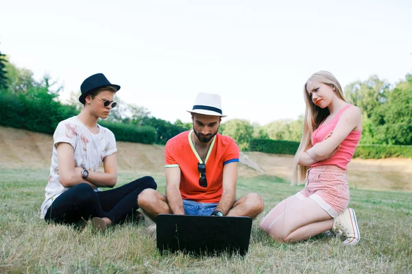 Technology and people concept - group  friends with tablet pc computers , smartphone sitting  in park — Stock Photo, Image