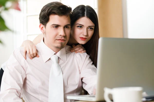 Gelukkige jonge ontspannen paar werken op laptopcomputer — Stockfoto