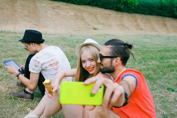 Retrato al aire libre del grupo de amigos tomando fotos con un smartphone en el parque — Foto de Stock