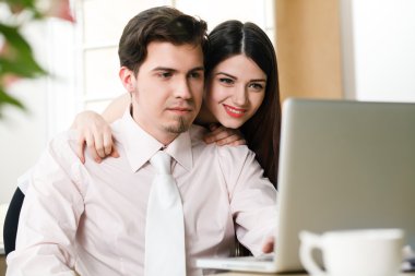 mutlu genç rahat çift dizüstü bilgisayar üzerinde çalışan