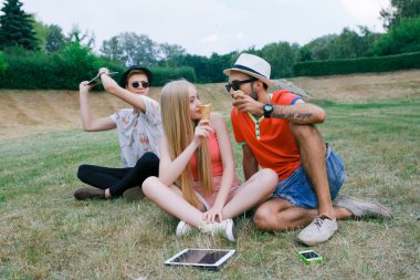 teknoloji ve insan kavramı - grup arkadaşları ile tablet pc bilgisayar, parkta oturan smartphone