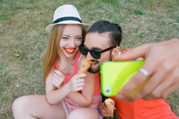 Outdoor portrait of group of friends taking photos with a smartphone in the park — Stock Photo, Image