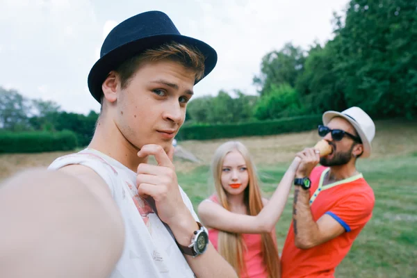 Retrato al aire libre del grupo de amigos tomando fotos con un smartphone en el parque — Foto de Stock